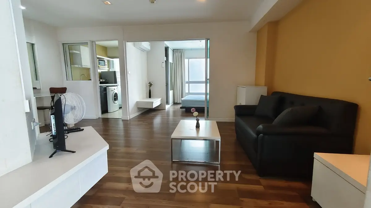 Spacious modern living room with hardwood floors and open layout in a stylish apartment.
