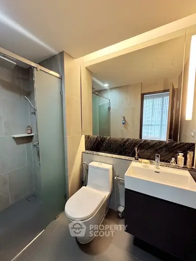 Modern bathroom with sleek design, glass shower, and elegant fixtures in a luxury apartment.