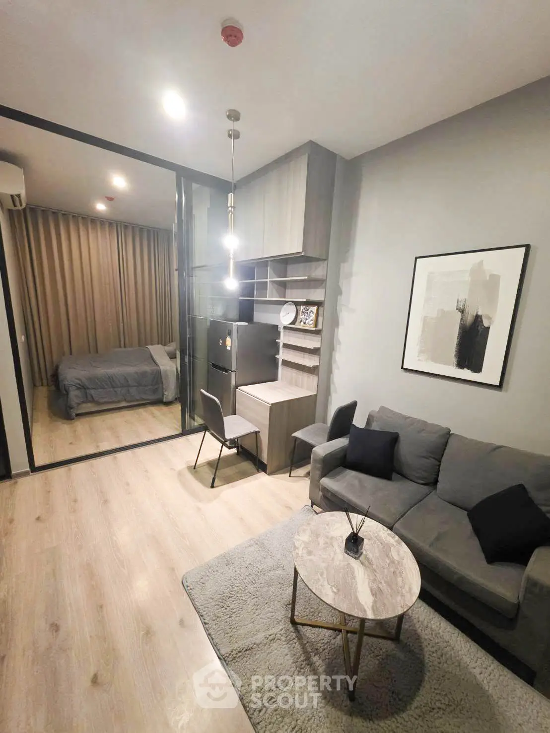 Modern living room with cozy seating and stylish decor in open-plan apartment.