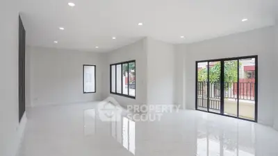 Spacious modern living room with large windows and glossy floors