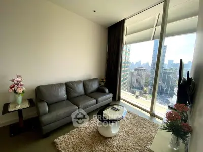 Modern living room with city view, featuring sleek furniture and large windows for natural light.