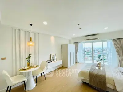 Spacious modern bedroom with city view, elegant decor, and cozy dining area.