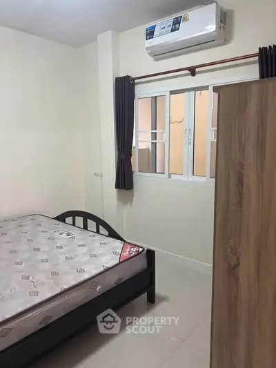 Cozy bedroom with air conditioning and modern furnishings, perfect for comfortable living.