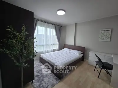 Modern bedroom with large window, minimalist decor, and cozy atmosphere.