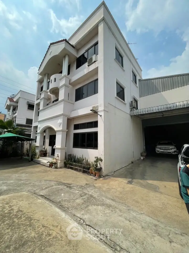 Charming three-story building with garage and driveway, perfect for residential or commercial use.