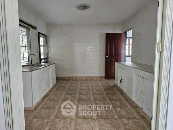 Spacious kitchen with tiled flooring and ample natural light