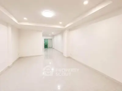 Spacious and bright empty room with modern lighting and tiled flooring, perfect for customization.