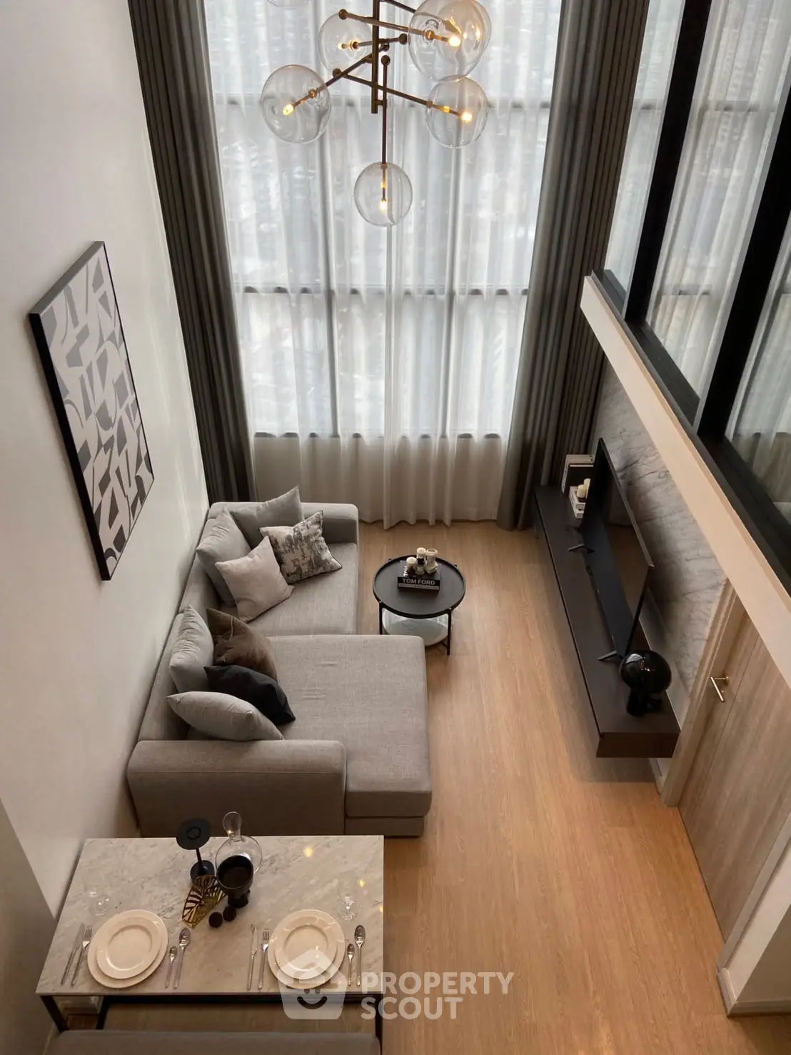 Modern loft-style living room with high ceilings, elegant decor, and large windows for natural light.