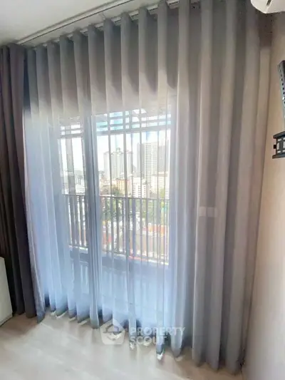 Spacious apartment with floor-to-ceiling windows offering stunning city views.