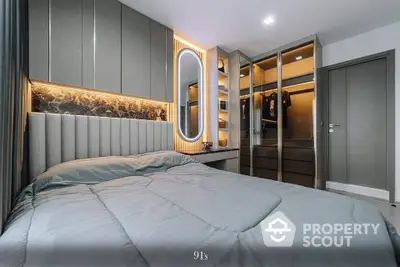 Luxurious bedroom with modern design, featuring an elegant bed with plush headboard, stylish lighting, and mirrored wardrobe doors enhancing the spacious feel.