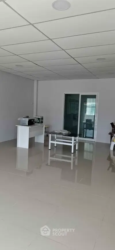 Spacious modern living room with sleek tiled flooring and minimalist decor, perfect for contemporary living.