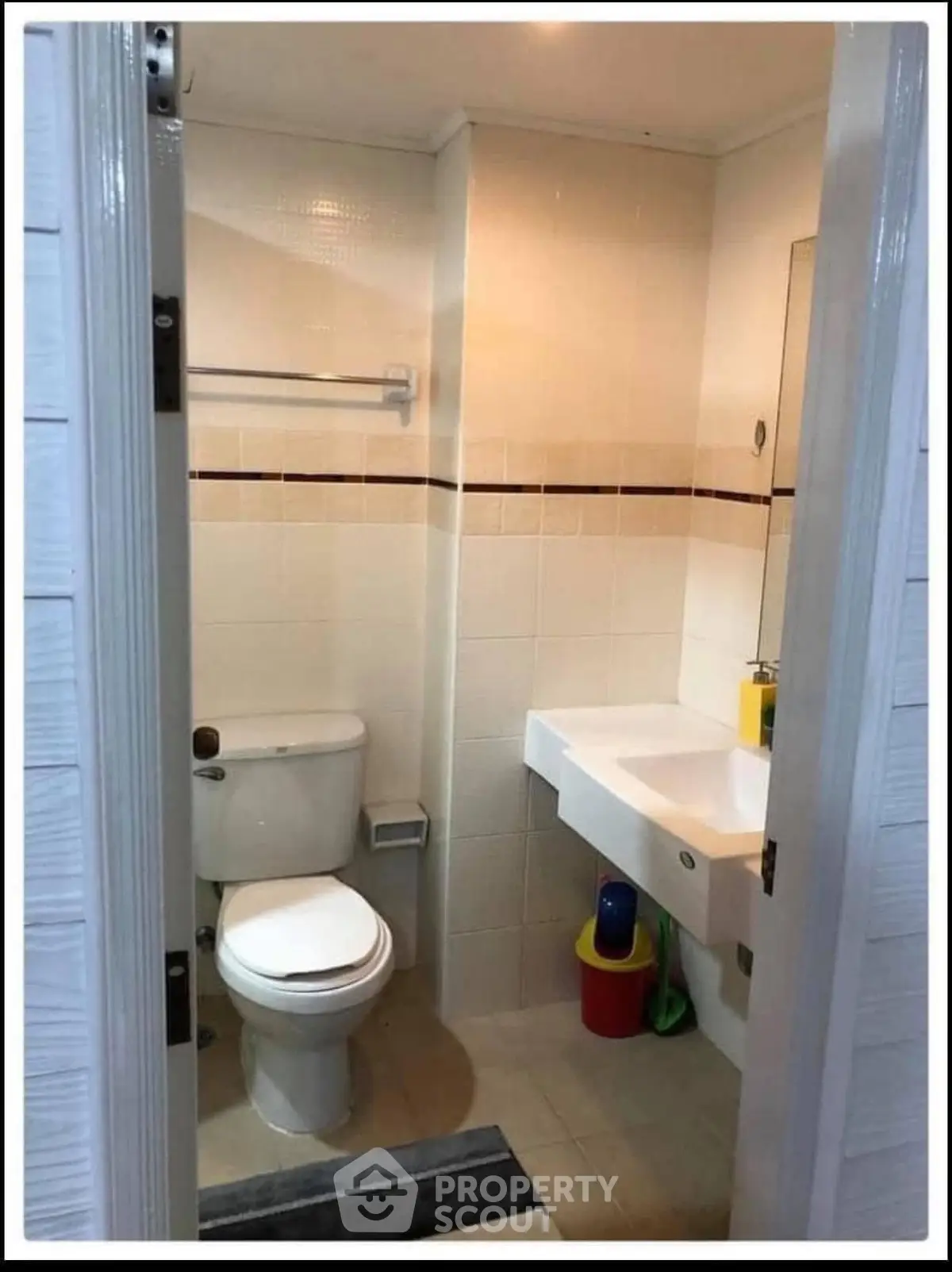 Compact bathroom with modern fixtures and tiled walls, featuring a toilet and sink.