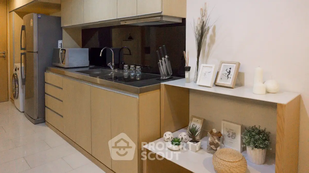 Modern kitchen with sleek cabinetry and appliances in a stylish apartment.