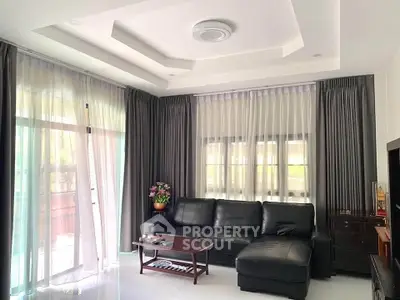 Elegant living room with modern ceiling design and large windows