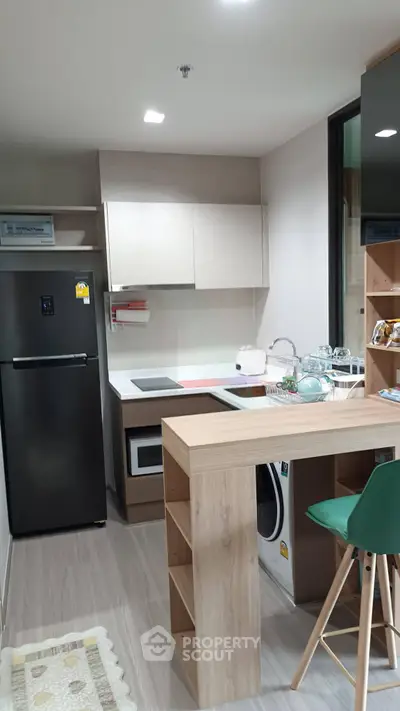 Modern kitchen with sleek appliances and stylish breakfast bar in contemporary apartment.