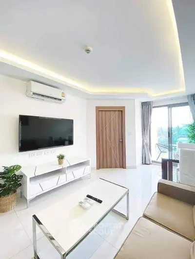 Modern living room with sleek furniture and natural light from large windows.