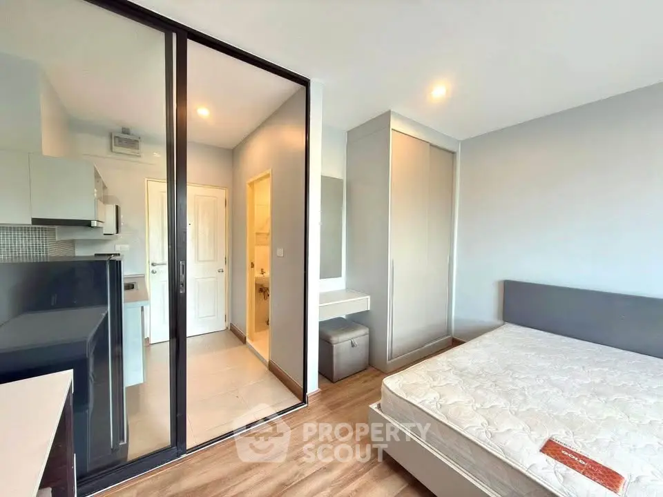 Modern bedroom with ensuite bathroom and sleek kitchen in a stylish apartment.