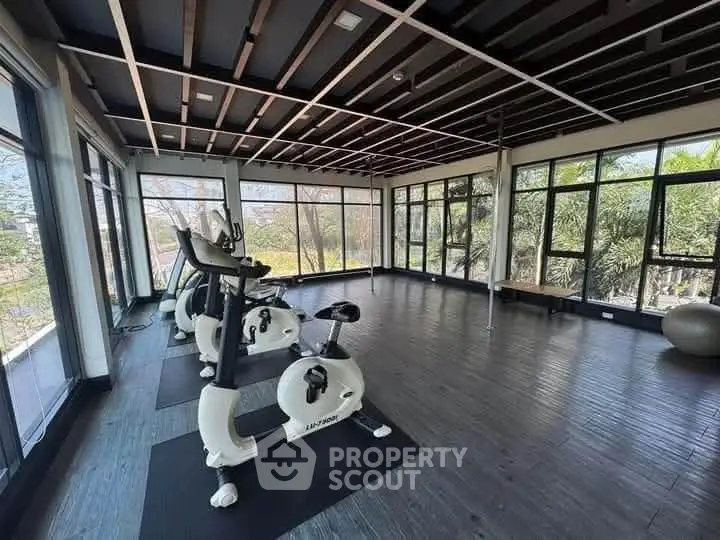 Spacious gym with modern exercise bikes and panoramic windows offering scenic views.