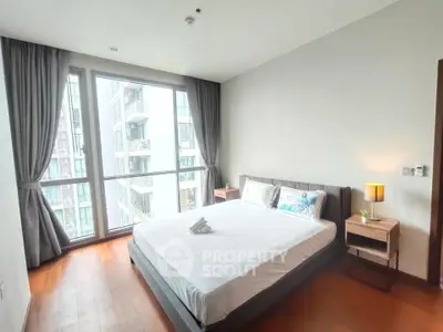 Modern bedroom with large window and city view in a high-rise apartment.