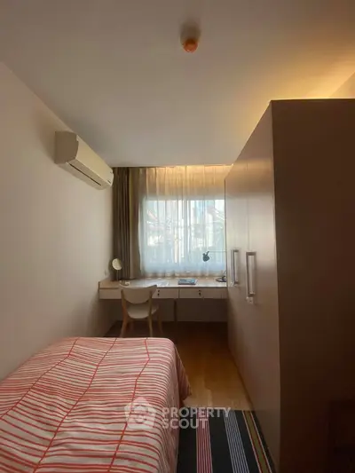 Cozy bedroom with modern desk and ample natural light, perfect for a serene living space.