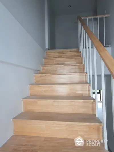 Modern wooden staircase with sleek railing in contemporary home