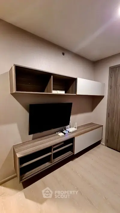 Modern living room with sleek wall-mounted TV unit and storage cabinets.
