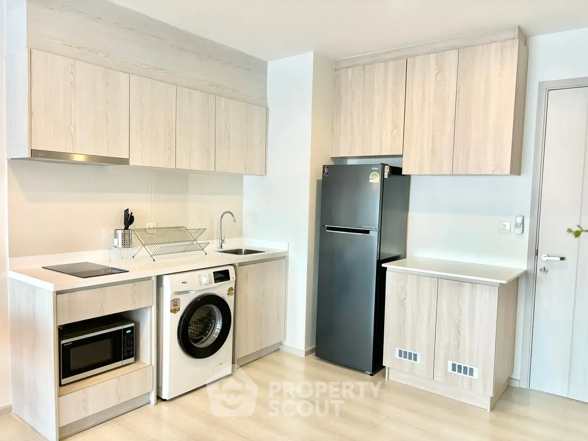 Modern kitchen with sleek appliances and light wood cabinetry