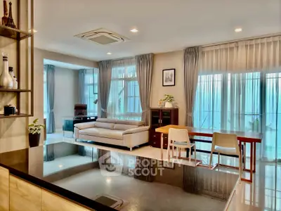 Spacious modern living room with elegant decor and large windows for natural light.