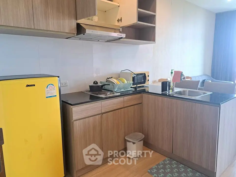 Modern kitchen with yellow fridge and open layout in cozy apartment