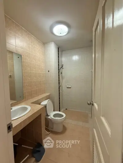 Spacious bathroom with modern fixtures and tiled walls in a cozy apartment.