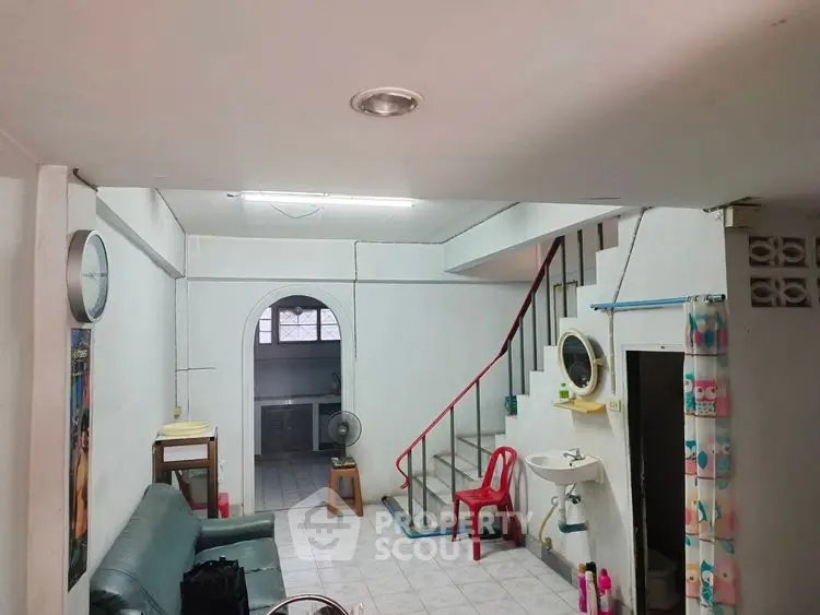 Cozy living room with staircase and open access to kitchen area