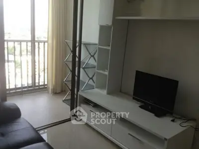 Modern living room with balcony view and sleek entertainment unit.