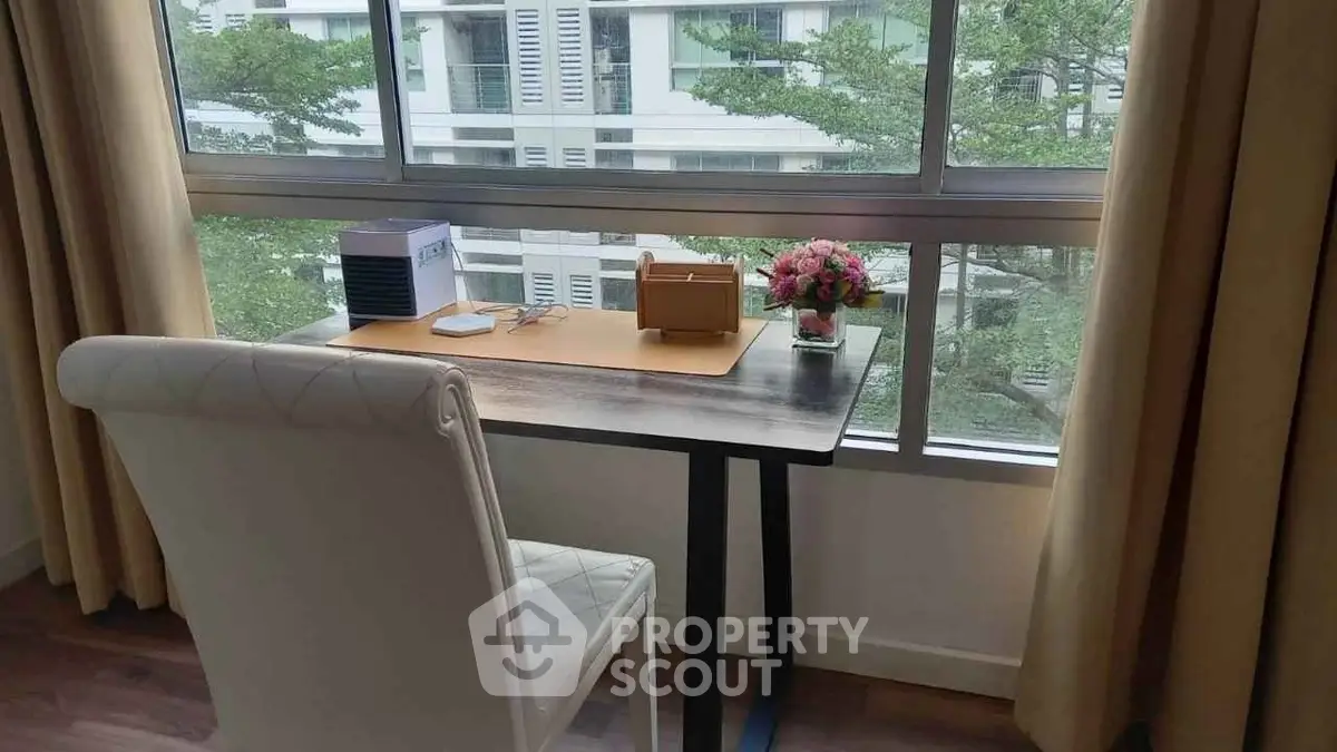 Cozy study area with a window view, featuring a stylish desk and comfortable chair.