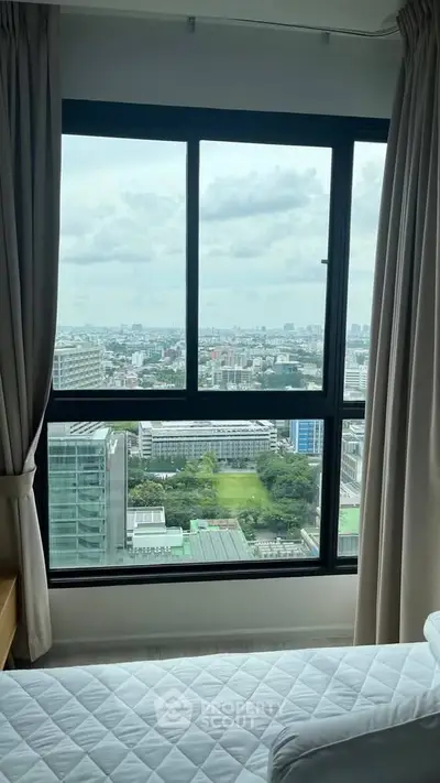 Stunning city view from a high-rise bedroom window, offering a serene and expansive urban landscape.