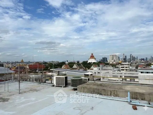 Stunning rooftop view of city skyline with clear blue sky, perfect for urban living enthusiasts.