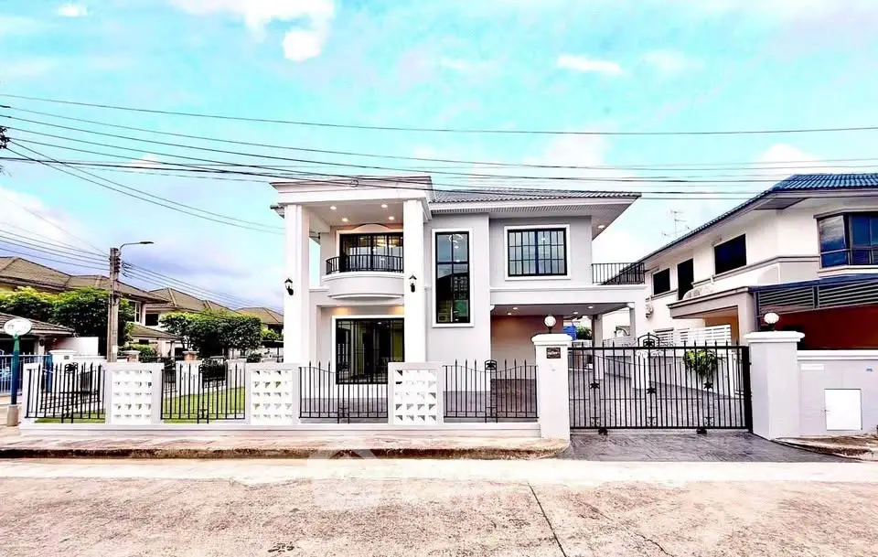 Stunning modern two-story house with gated entrance and spacious driveway in a serene neighborhood.