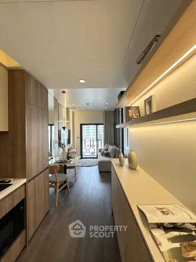 Modern living room with open kitchen, wooden flooring, and stylish decor in a cozy apartment.