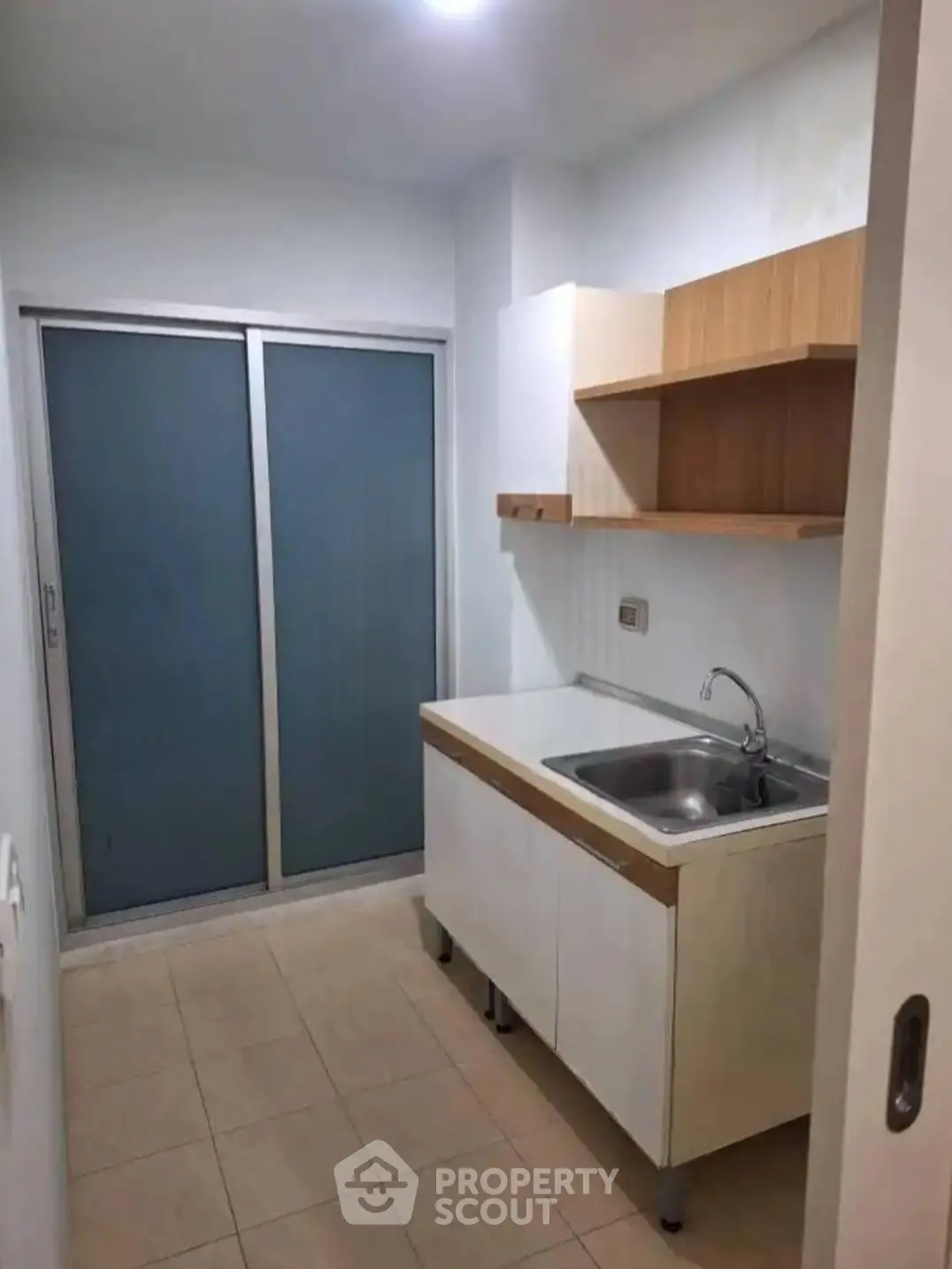 Compact kitchen with modern cabinetry and sliding door