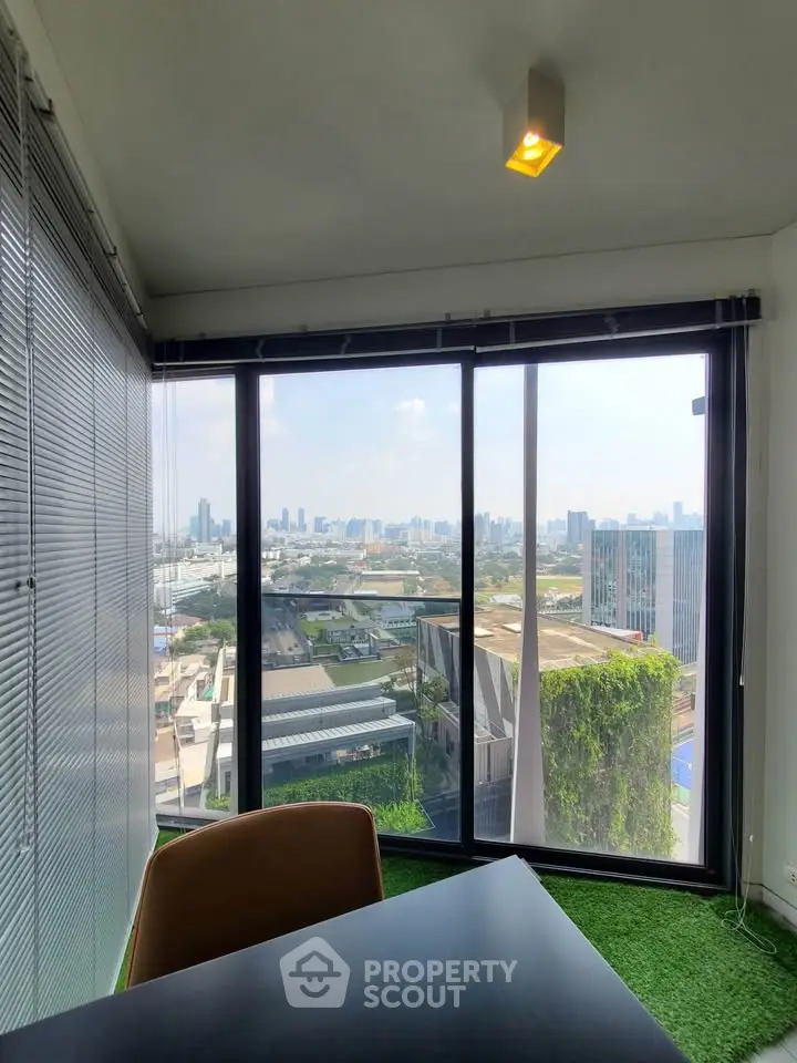 Stunning office view with floor-to-ceiling windows overlooking city skyline and lush greenery.