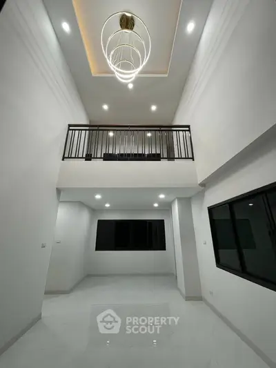 Modern high-ceiling living room with elegant lighting and large windows