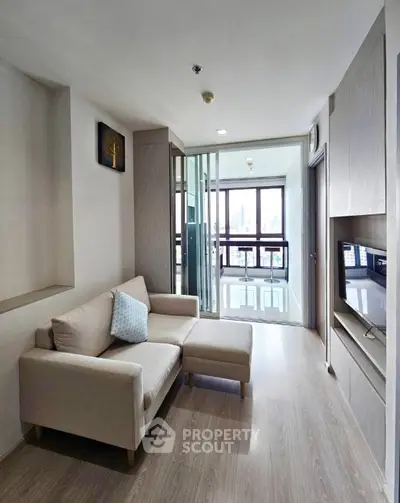 Modern living room with sleek design and city view, featuring a cozy sofa and large windows.