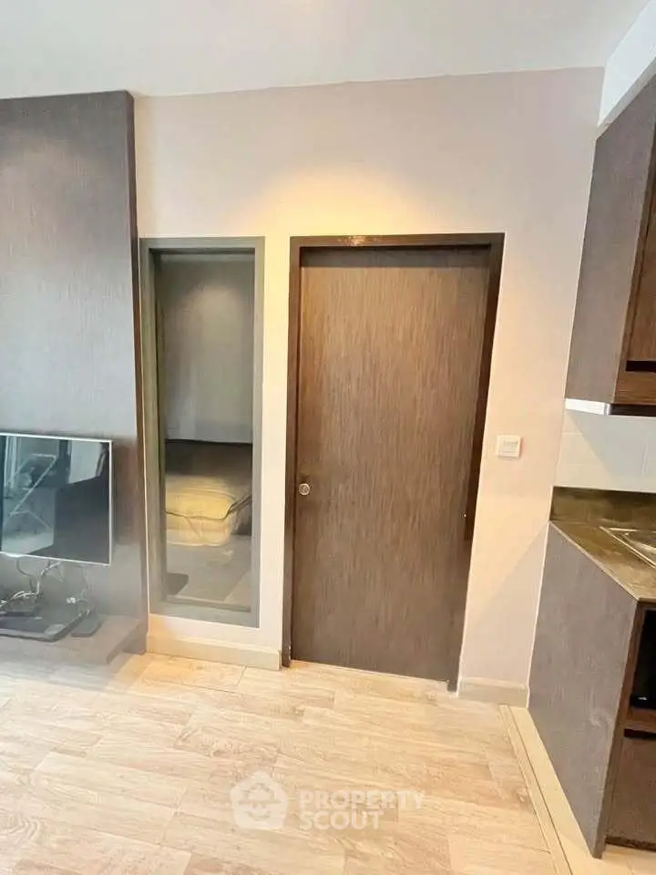 Modern living room with sleek wooden flooring and built-in TV unit, showcasing contemporary design.