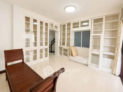 Spacious living room with built-in shelves and elegant wooden seating