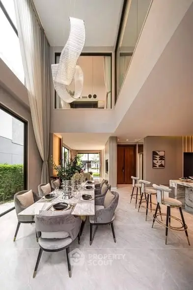 Luxurious open-plan living and dining area with high ceilings and modern decor.