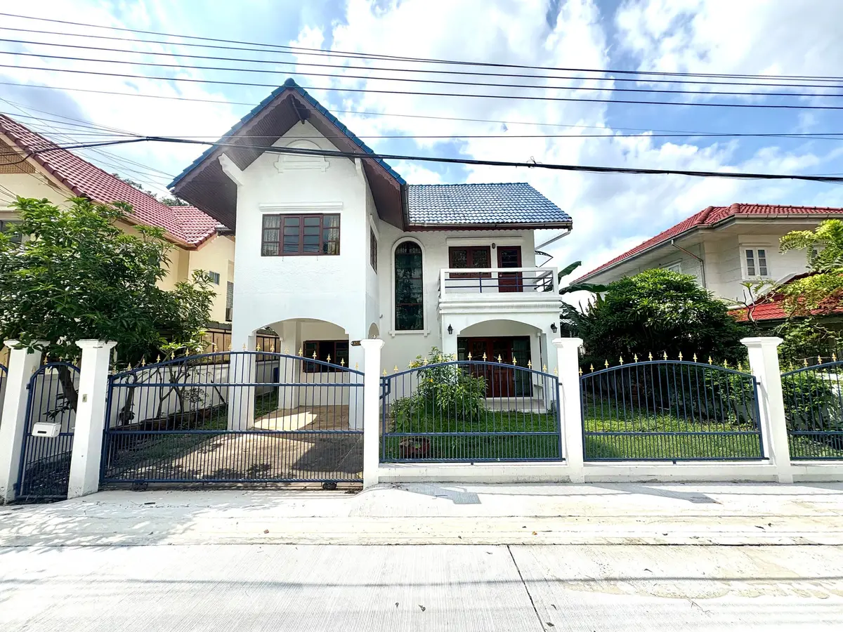 Charming two-story house with a spacious front yard and classic architectural design, perfect for family living.