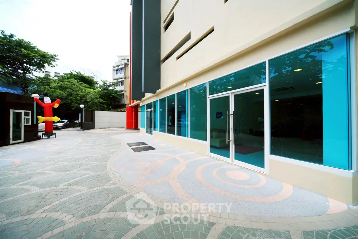 Modern building exterior with large glass windows and unique pavement design