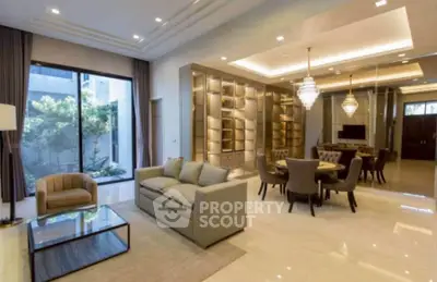 Luxurious open-plan living and dining area with elegant lighting and garden view.