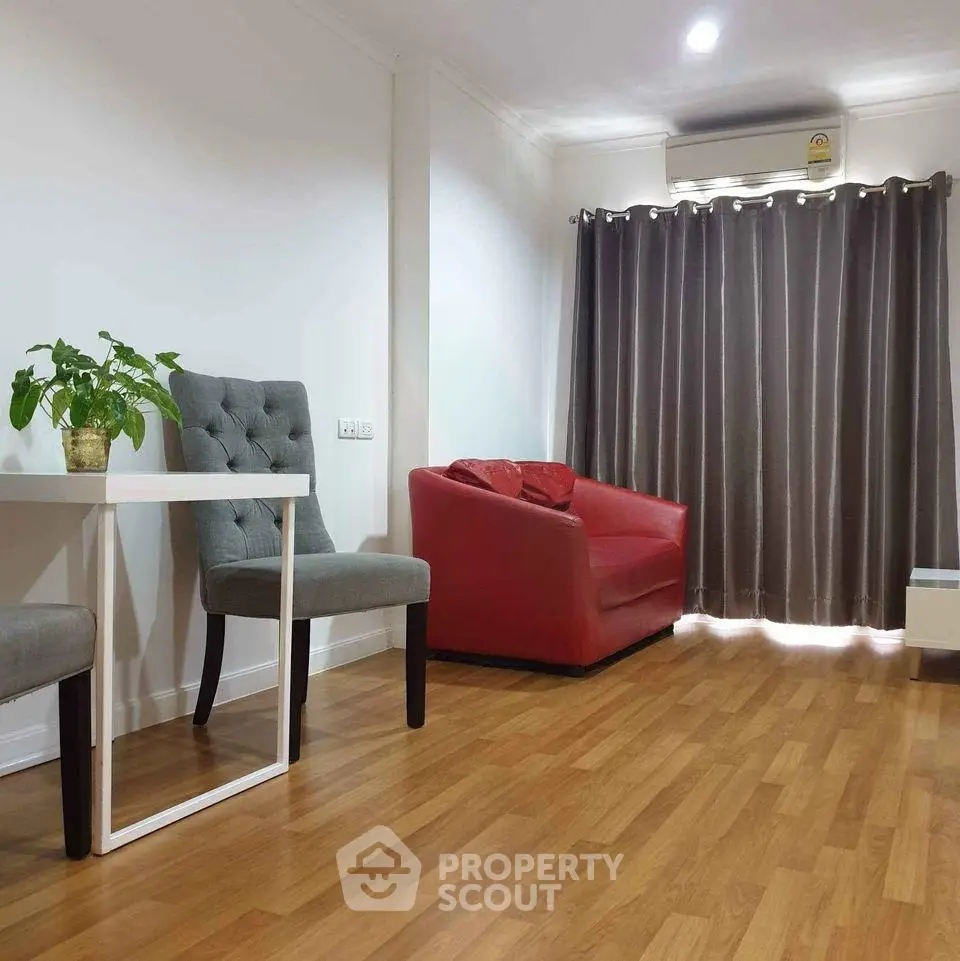Cozy living room with wooden flooring, red sofa, and modern decor