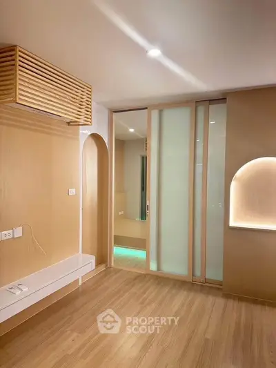 Modern minimalist room with wooden flooring and sliding glass doors, perfect for a cozy living space.