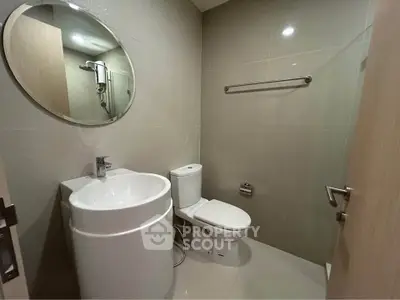 Modern bathroom with sleek fixtures and round mirror, ideal for contemporary living.